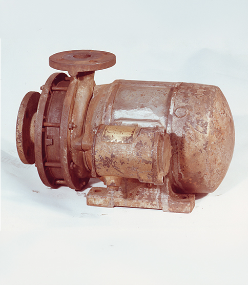 <h3>Développement de la pompe à rotor noyé</h3> Historic centrifugal pump with electric motor, mounted on a base plate, showing significant age.