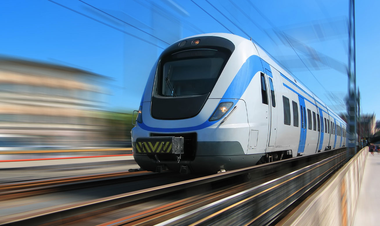 <h2>Solutions de pompes pour les circuits de refroidissement des véhicules ferroviaires</h2> Modern white and blue passenger train speeding through a station, motion blur emphasizing high velocity travel.